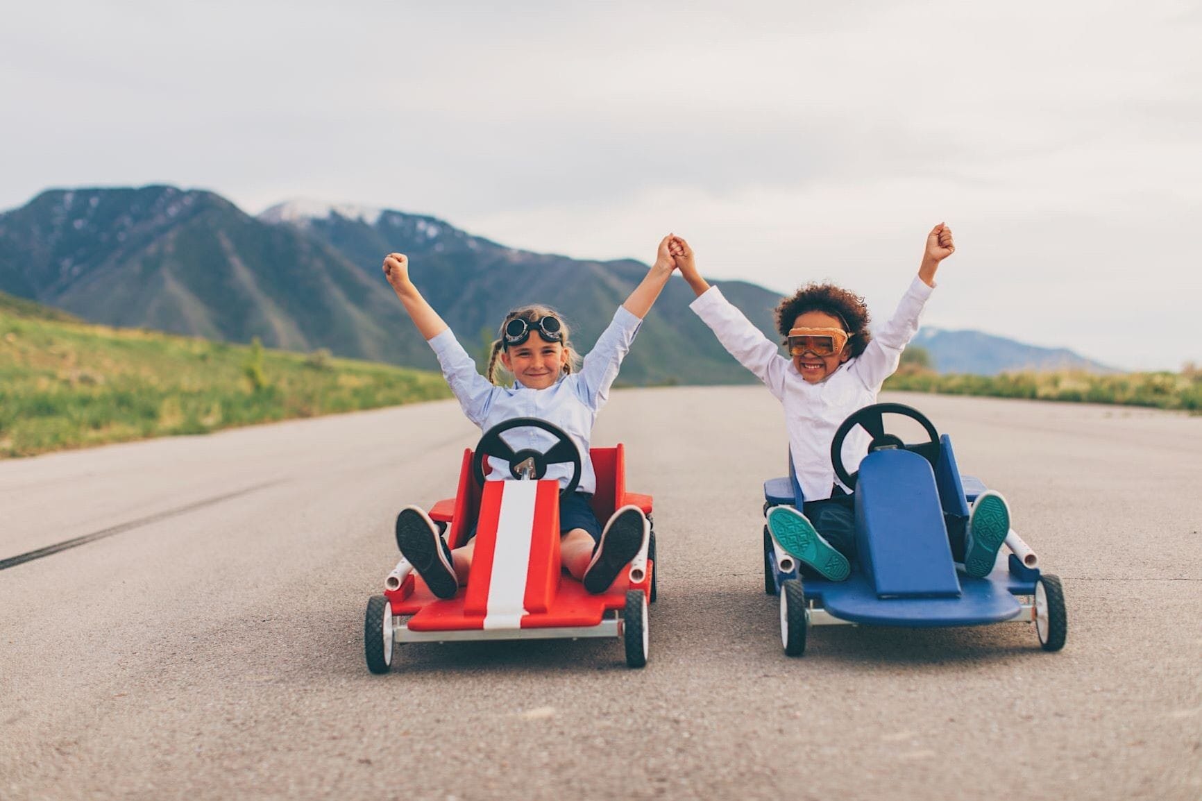 Two girls each in a Soapbox Derby car